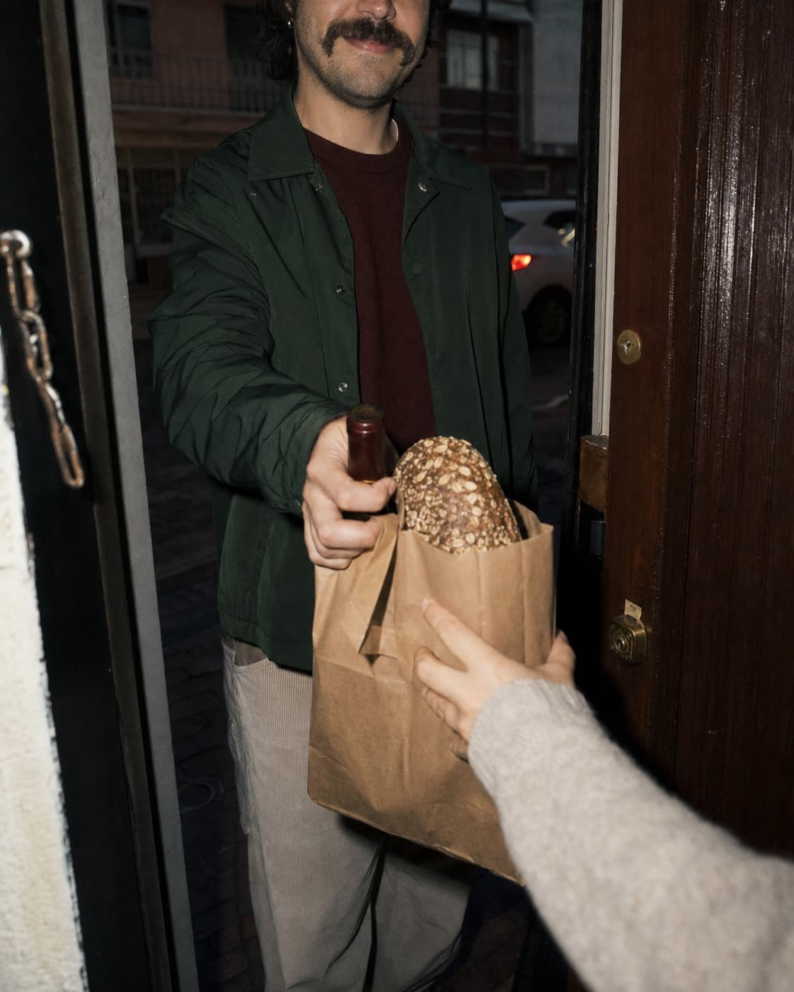 Una bolsa con pan y vino llegando a una casa en Bogotá